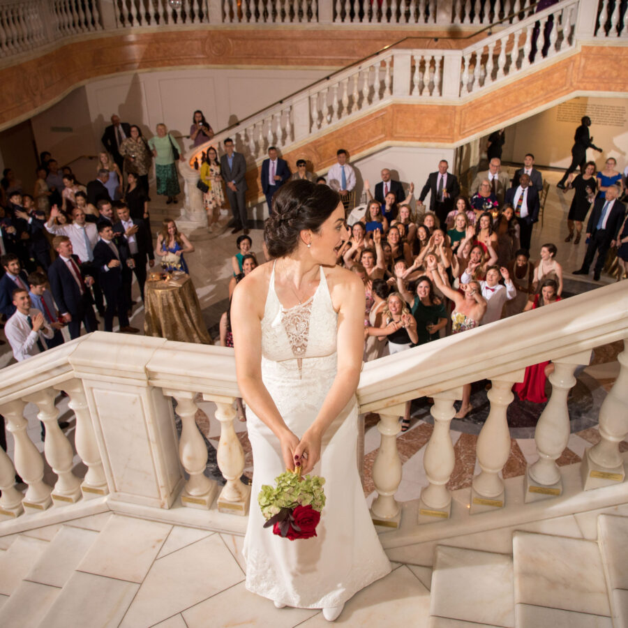 Photo of a bride throwing her bouquet to her wedding guests.