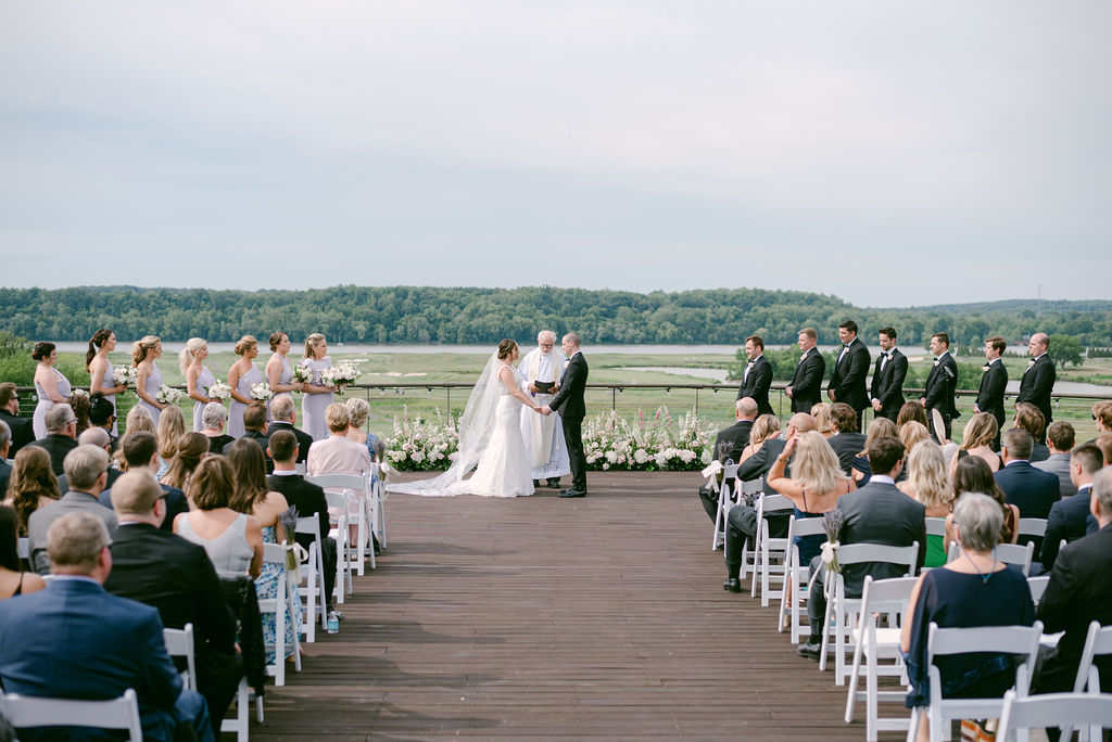Photo of a wedding party at a wedding ceremony with a river view 