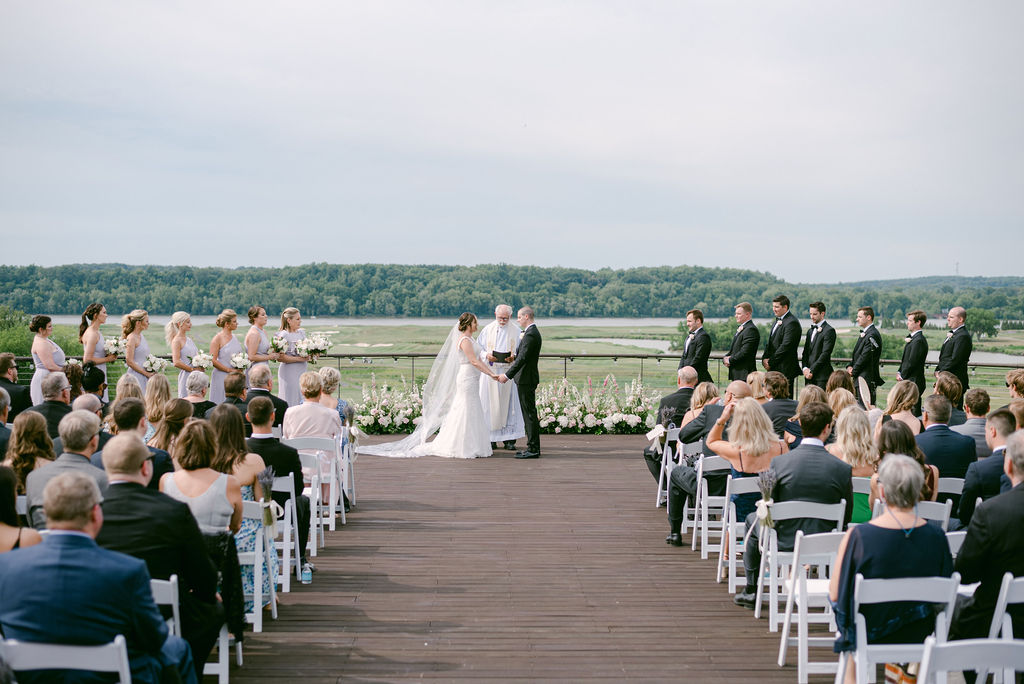 Photo of a wedding party at a wedding ceremony with a river view